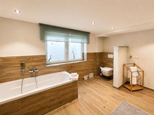 a large bathroom with a tub and a toilet at Ferienwohnung Resi´s Welfenoase in Schwangau