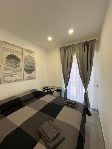 a bedroom with a black and white bed and a window at Brothers house in Genzano di Roma