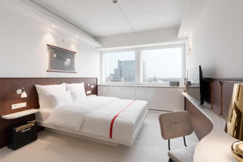 a bedroom with a large white bed and a window at Ruby Luna Hotel Dusseldorf by IHG in Düsseldorf