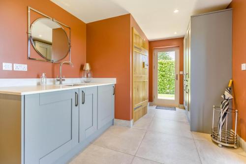 a bathroom with orange walls and a sink and a mirror at 3 Bed in Hereford oc-83659 in Madley