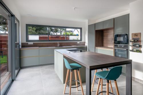 a kitchen with a wooden table and blue stools at violette in Pornichet