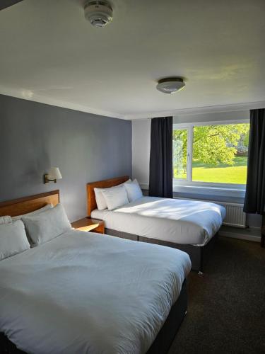 a hotel room with two beds and a window at Sporting Lodge Inn Middlesbrough in Middlesbrough