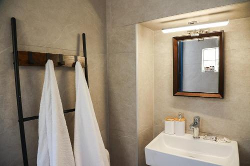 a bathroom with a white sink and a mirror at Town Apartment in Mikonos