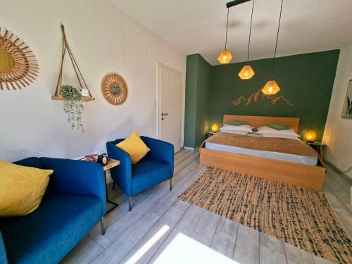 a bedroom with a bed and two blue chairs at La Vida appartment 1 in Klagenfurt