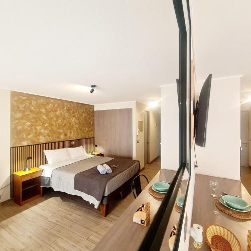 a hotel room with a bed and a table at Deptos Estudios y de 2 dormitorios, Central, San Martin 2426. Sector Mall Plaza, Cowork y Factura. in Antofagasta