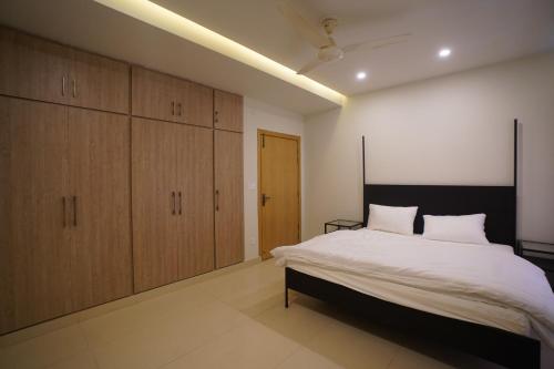 a bedroom with a large bed and wooden cabinets at Oasis Living in Islamabad