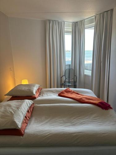 a bedroom with two beds and a window at Strandappartement Iselmar Makkum nr 30 in Makkum