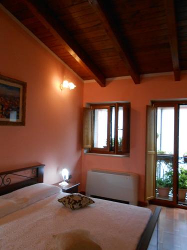 a bedroom with orange walls and windows and a bed at I QuattroGioielli in SantʼAngelo le Fratte