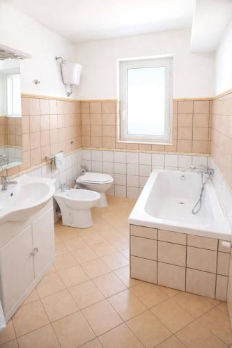 a bathroom with two sinks and a tub and a toilet at HOUSE IN PARADISE - Realmonte with Free parking in Realmonte