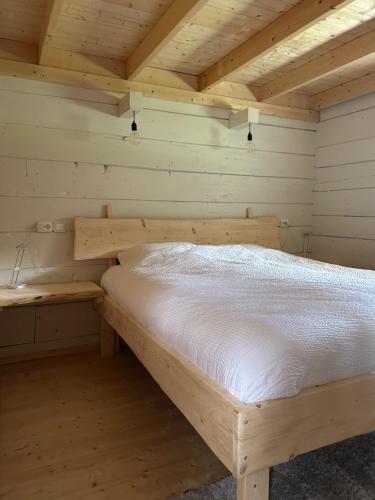 a room with a bed in a wooden room at Deer Cottage in Sylte
