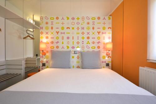 a bedroom with a white bed and a wall with mathematical signs at Ibis Styles La Louvière in La Louvière