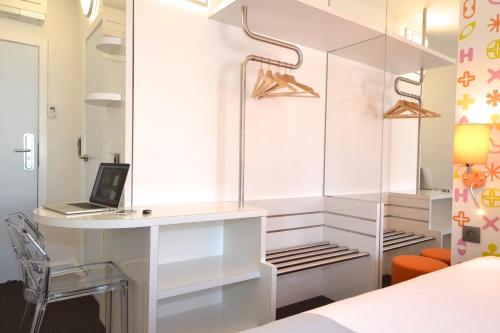 a bedroom with a desk with a laptop on it at Ibis Styles La Louvière in La Louvière