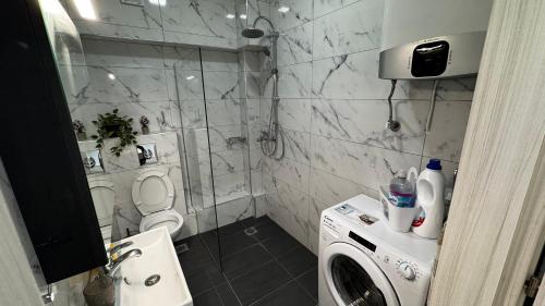 a bathroom with a shower and a washing machine at Bella Luxury Suite II in Paralia Katerinis