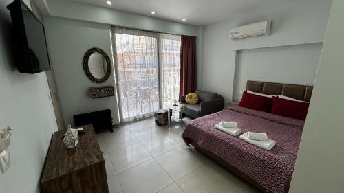 a bedroom with a bed and a large window at Bella Luxury Suite II in Paralia Katerinis