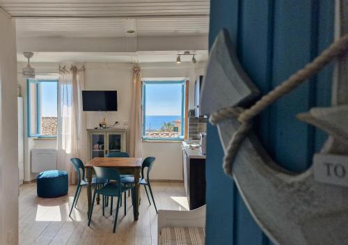 a living room with a table and chairs and a kitchen at Loft Azzurro Old City Center in Rio Marina