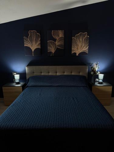 a bedroom with a bed with blue walls and pictures on the wall at Aura Maris in Guspini