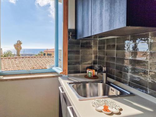 a kitchen with a sink and a large window at Loft Azzurro Old City Center in Rio Marina