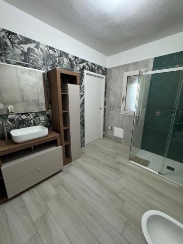 a bathroom with a sink and a glass shower at Aura Maris in Guspini