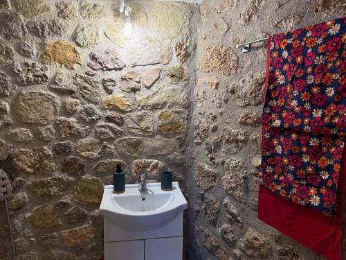 a bathroom with a sink and a stone wall at Georgoulis Home in Ambelókipoi