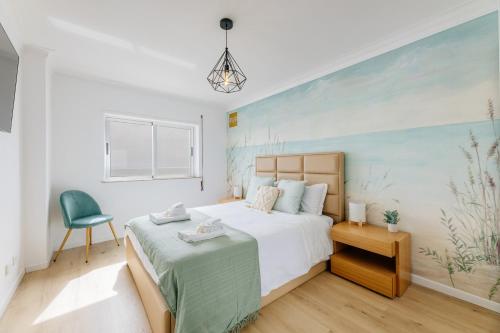 a bedroom with a large bed and a chair at BESTVILLAS Âncora Rio in Vila Praia de Âncora