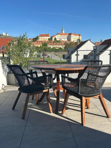 a wooden table and chairs sitting on a patio at Apartmány Pod Novou in Mikulov