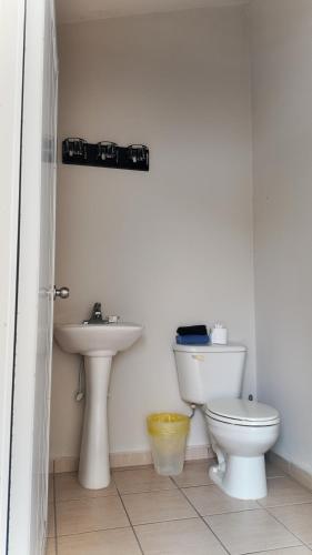 a bathroom with a toilet and a sink at Landing View 204 with private rooftop terrace in Rincon