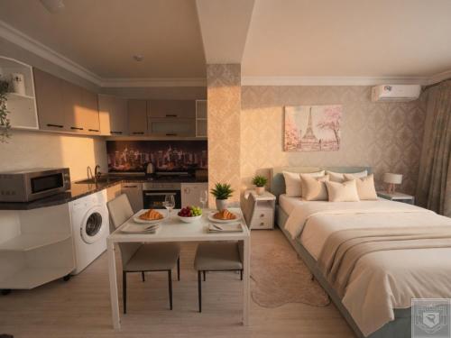 a bedroom with a bed and a table and a kitchen at RentHouse Apartments Smart-Accomodation in Chişinău