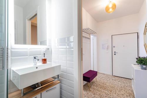 a white bathroom with a sink and a mirror at Rigoletto Apartments by Fenix in Venice