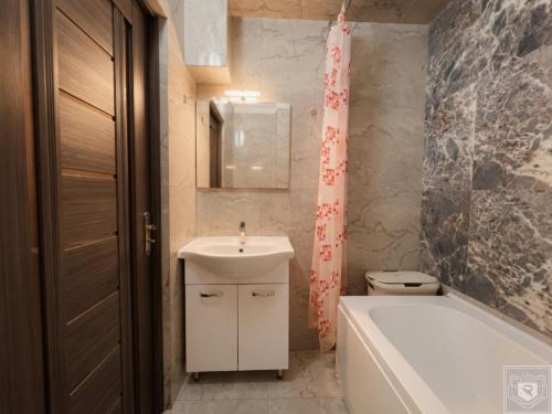 a bathroom with a sink and a tub and a toilet at RentHouse Apartments Smart-Accomodation in Chişinău