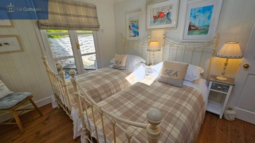 a bedroom with two beds and a window at The Summer House in Saint Mawes