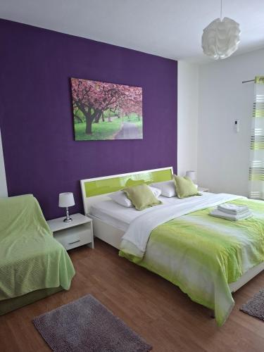 a bedroom with two beds and a purple wall at Enjoy in Omiš
