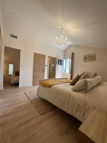 a bedroom with two beds and a chandelier at La Bastide des Trembles- Hôtel particulier avec piscine proche IPC et Vélodrome in Marseille