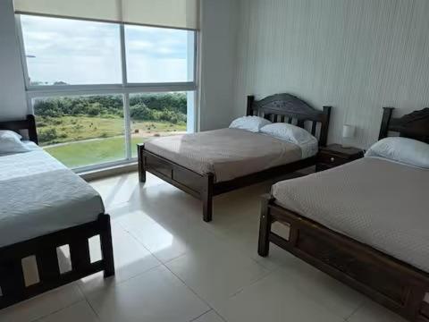 a bedroom with two beds and a large window at Playa Blanca Ocean ll in Playa Blanca