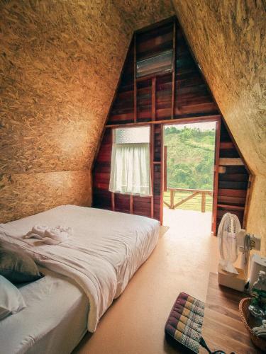 a bedroom with a bed in a room with a window at เคียงสะปันโฮม&คาเฟ่ in Ban Huai Ti