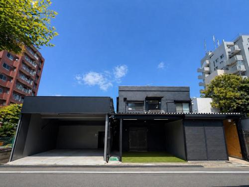 a modern house with a black facade on a street at D旅館　Dryokan in Tokyo