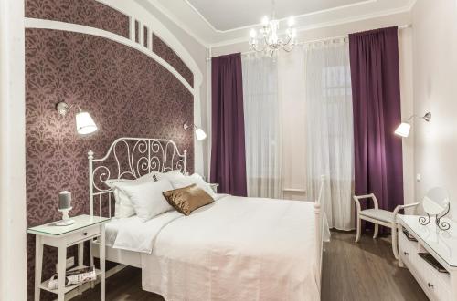 ein Schlafzimmer mit einem weißen Bett und lila Wänden in der Unterkunft InretroRed_byApartica in Sankt Petersburg