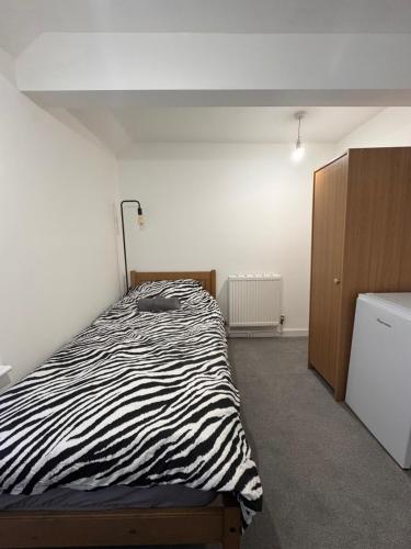 a bedroom with a zebra print bed and a dresser at Serenity LTD in Leicester