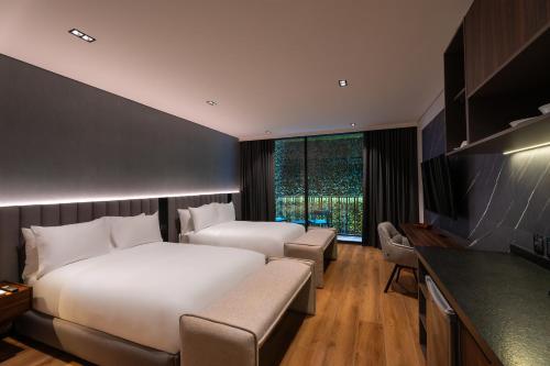 a hotel room with two beds and a television at Ambulan Mexico City in Mexico City