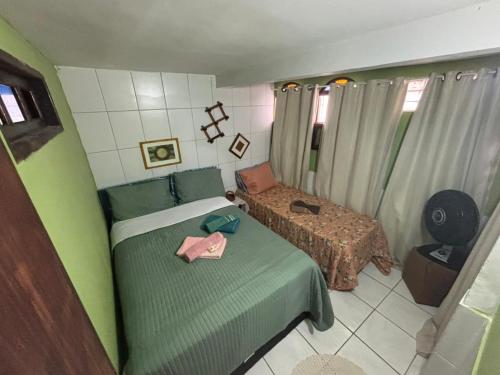 a small bedroom with a bed and a table at Jully''s house in Arraial do Cabo