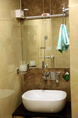 a bathroom with a white sink and a mirror at Elite Residency Bhadrachalam in Bhadrāchalam