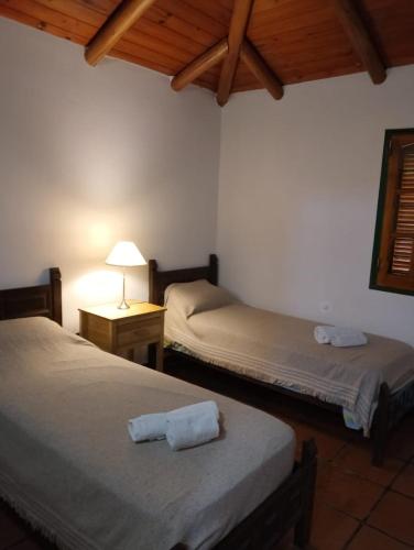 a bedroom with two beds and a lamp on a table at Casa Fauna in Mendiolaza