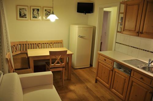 a kitchen with a refrigerator and a table and a table at Landhotel Berger in Eben im Pongau