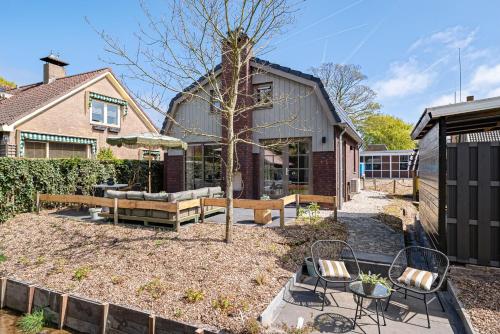 a yard with two chairs and a tree at Huize Duingeluk in Schoorl