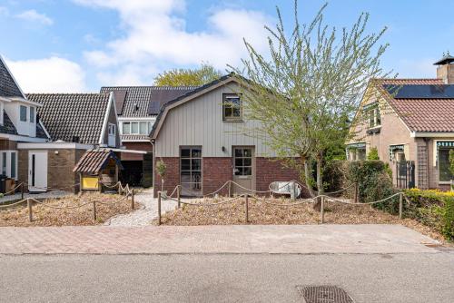 a house with a fence in front of it at Huize Duingeluk in Schoorl