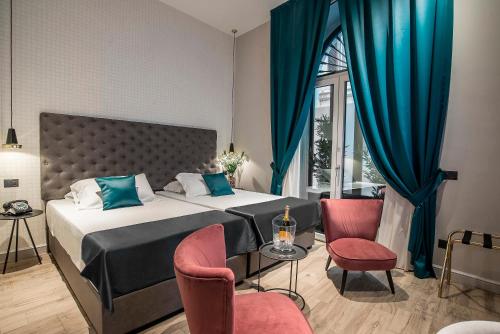 a bedroom with a bed and two chairs and a window at Navona Street Hotel in Rome