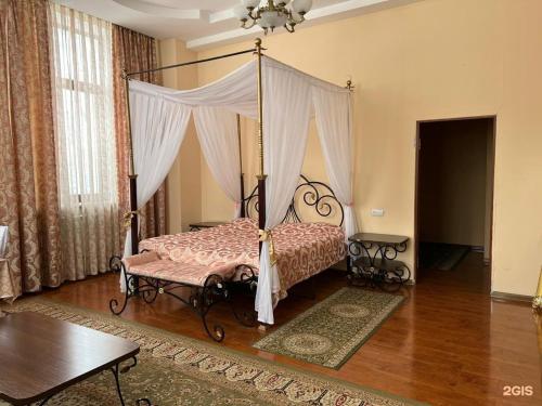 a bedroom with a canopy bed in a room at Edelweiss in Almaty
