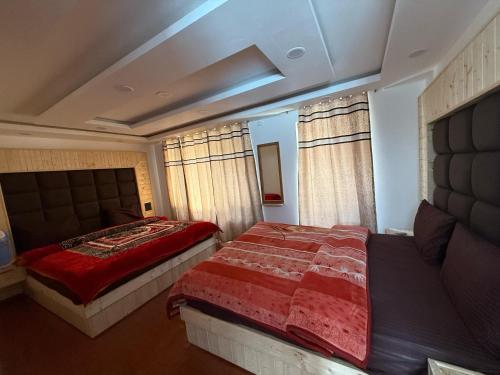a bedroom with a bed with a red comforter at New Heaven Rose in Pahalgām