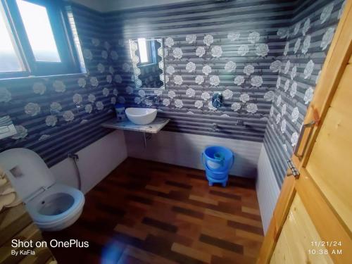 a small bathroom with a toilet and a sink at New Heaven Rose in Pahalgām