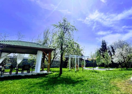 a gazebo with a table and a tree in a field at Mountain View Deluxe Villa & pool in Gabala