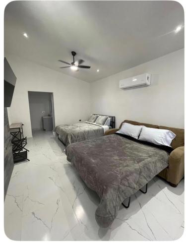 a bedroom with two beds and a ceiling fan at El Retiro Villas & Pádel - Villa 3 in Parras de la Fuente